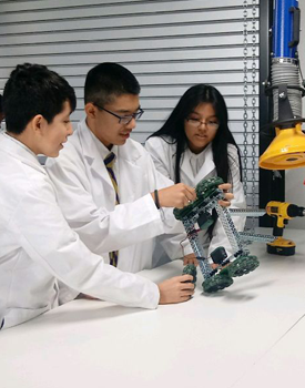 Students manipulating a robotic creation